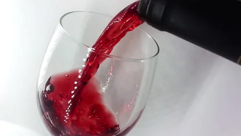Pouring wine from a bottle into a glass slow motion Stock Footage 146897953