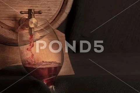 Pouring wine into a glass from an oak barrel, a panoramic close-up shot on a Stock Photos