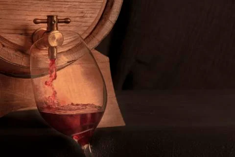 Pouring wine into a glass from an oak barrel, a panoramic close-up shot on a Stock Photos