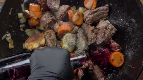 Pouring wine to make Beef Bourguignon in a wok. Top view Stock Footage 329277513