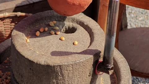 Pouring yellow coffee beans in to the ancient hand mill. Stock Footage 304647315
