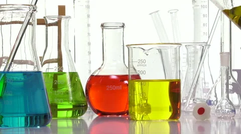 Pouring yellow liquid in a beaker using an Elenmeyer Video stock 64290451