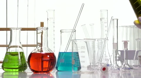 Pouring yellow liquid in a beaker using an Elenmeyer Video stock 64290473