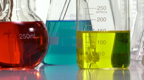 Pouring yellow liquid in a beaker using an Elenmeyer Video stock 64291340