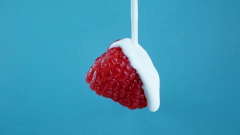 Pouring yoghurt from the top over a raspberry in Slow Motion 1000fps Stockbeeldmateriaal 330533078