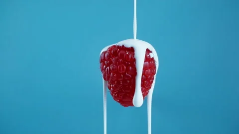 Pouring yoghurt from the top over a raspberry in Slow Motion 1000fps Stock Footage 330533111