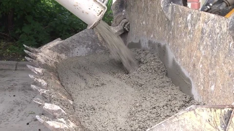 Pours cement into the bucket of the excavator Stock Footage