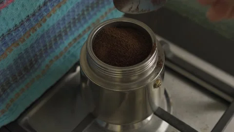Pours coffee into a geyser coffee maker standing on a gas stove HLG REC2020 Video stock 229351157