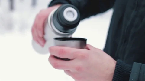 Pours hot tea in the winter forest Stock Footage 76604837