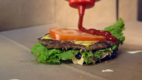 Pours ketchup on a hamburger Vídeo Stock 84817288