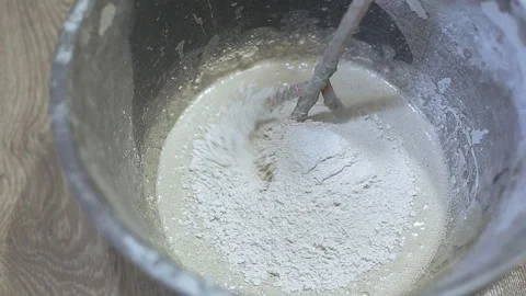 Pours plaster into the construction bucket and stirred Stock Footage 106242749