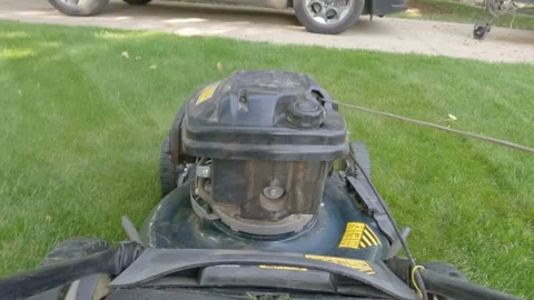 POV action camera mounted on a noisy lawnmower as it is pushed back and forth Stock Footage 249838361
