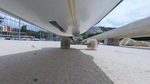 POV action camera mounted under longboard, low angle view of wheels on concrete Stock Footage 318147576