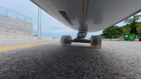 POV action camera mounted under longboard, low angle view of wheels on concrete Stock Footage 318153610