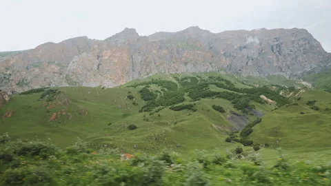 POV Action Driving View Of Massive Rocky Mountain Wall And Green Slopes Видео 347658013