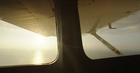POV aerial view from inside small plane at sunrise over ocean Stock-Footage 75919010