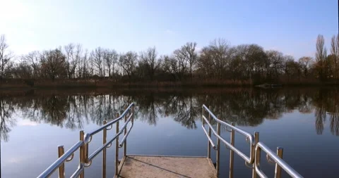 POV approaching river edge from dock with staircase handrails in view. Stock Footage 300364030