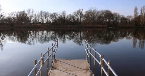 POV approaching river edge from dock with staircase handrails in view. Stock Footage 300364054