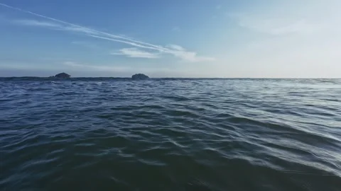POV of bather in evening ocean as waves roll in golden droplets spray close Video stock 327724422