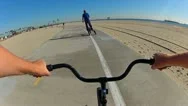 Pov Bike Following Trikke Rider At Beach Stock Footage