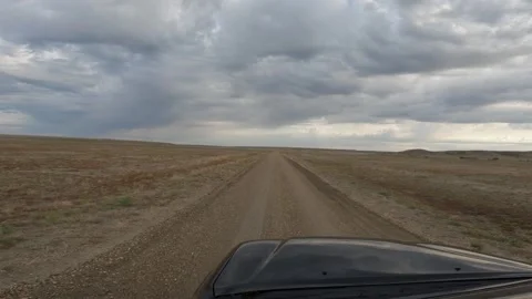 POV from a black truck moving forward on an isolated gravel road through a Stock Footage 326969701