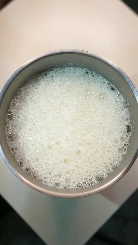 A POV of bubbles bursting in beer foam. A beer on the table. A beer tumbler Stock Footage 331231507