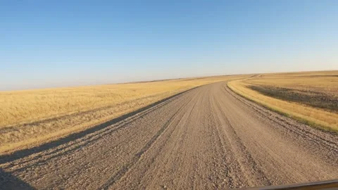 POV camera positioned on the front of a black vehicle that is driving on gravel Stock Footage 254025837