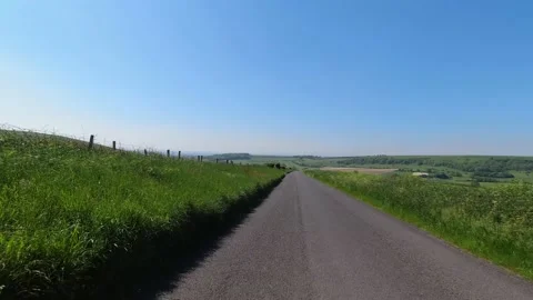 POV of a Car drive down a green, empty country lane on sunny day Stock Footage 155403361