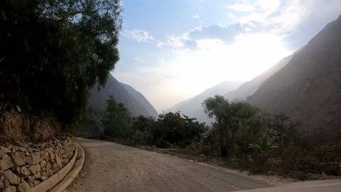 POV in the car driving between bushes and rocks on a narrow dirt road in the hig Vidéo 198798045