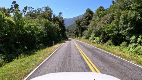 POV of car driving down towards mountains - New Zealand roadtrip Stock Footage 235715924