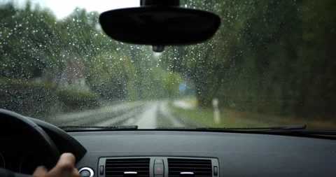 POV car interior driving in rain, wind blowing drops on windshield Stock Footage 343505410