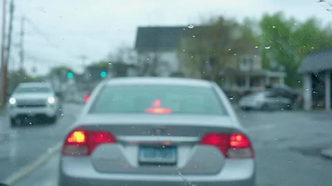 POV of car at red traffic light on a rainy day in the suburbs Stock Footage 333485953