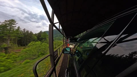 POV from a car on train platform crossing scenic mountain landscape, Swiss Alps Video stock 301548890