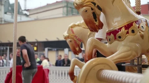 POV from carousel to city. Horses close up and down. Happy kids with parents Stock-Footage 81374591