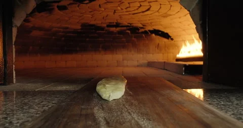 POV chef puts Turkish pide in stone oven. Fire burns in a stone oven in a Stock Footage 260848114