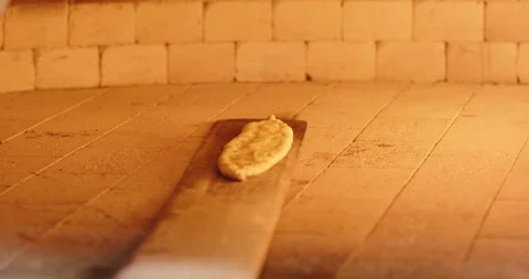 POV chef puts Turkish pide in stone oven. Fire burns in a stone oven in a Stock Footage 264910190