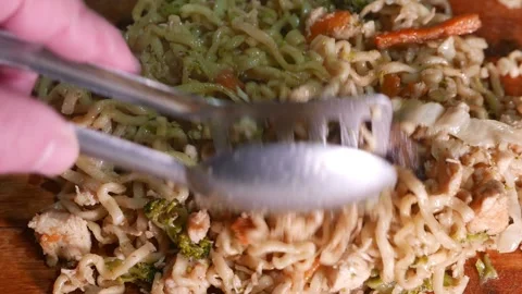 POV: chef stirring yakisoba on a table. Steam rises from the food. Hot Pasta Video stock 345404464