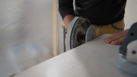 POV of construction worker in protective workwear sanding tile wall surface Stock Footage 327163202