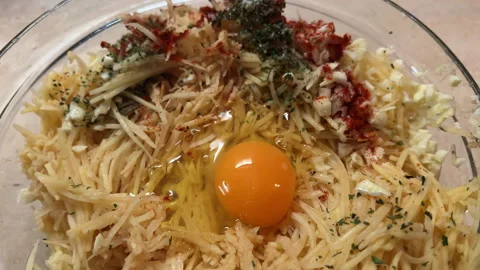 POV cooking hashbrowns. Adding egg into grated potatoes. Preparing potato pie Stock-Footage 260097948