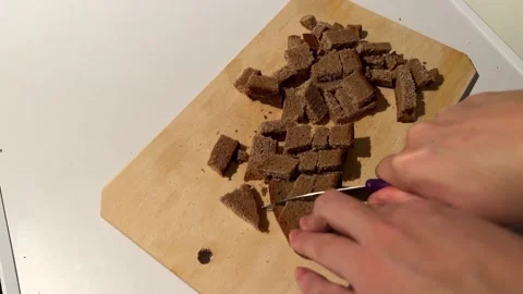 POV cutting dark rye bread into dices. Dicing brown bread for toast. Drying Stock-Footage 255659782