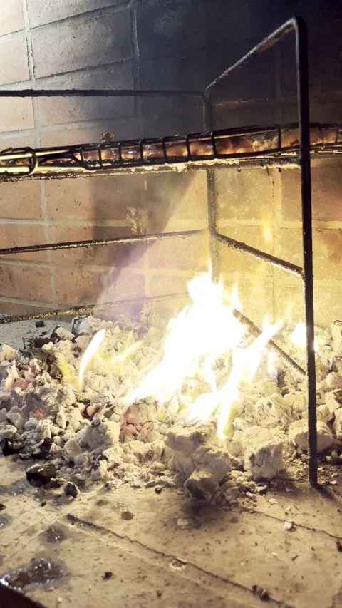 POV of dripping fat from meat ignite flames in hot coals during barbecue Video stock 345263627