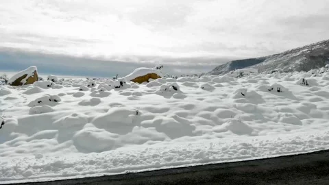POV-Drive Plate side-Passing snow covered sagebrush plain to mountain Stock-Footage 99479519