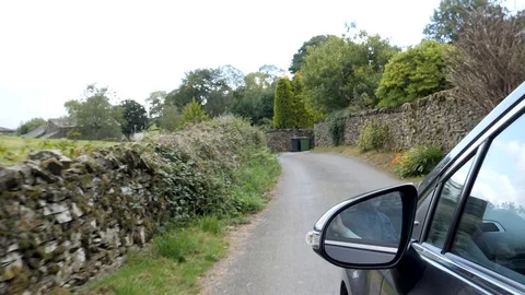 POV Drive Plate-View forward with side of car on rock wall lined Wales road Stock Footage 96161609