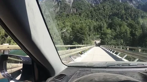 POV of a driver driving over a bridge looking through a window at a river Stock Footage 130662444