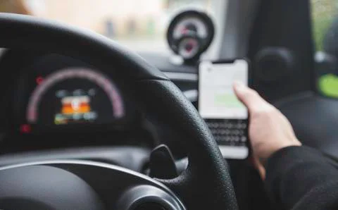 POV Driver on the phone whilst at the wheel of a car, texting and driving. Stock Photos