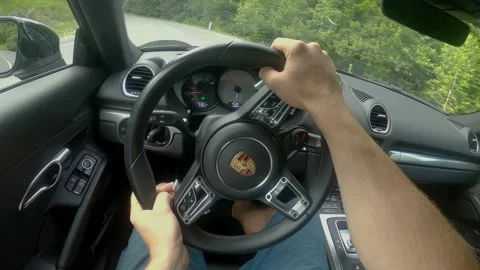 POV: Driving down empty country road winding through the forest in a new Porsche Stock Footage 138308757