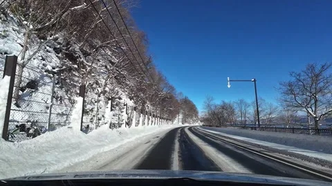 POV Driving on Empty Snowy Lake Road in Hokkaido Japan Winter Sunny Day Video stock 332938596