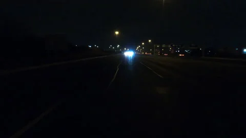 POV driving fast reverse shot at night on dark highway with car traffic Stockbeeldmateriaal 146925024