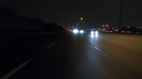 POV driving fast reverse shot at night on dark highway with car traffic Видео 146925626