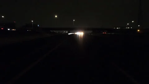 POV driving fast reverse shot at night on dark highway with car traffic Stockbeeldmateriaal 146933030